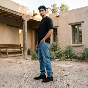 Hombre usando botín charro nobuck negro con jeans de mezclilla